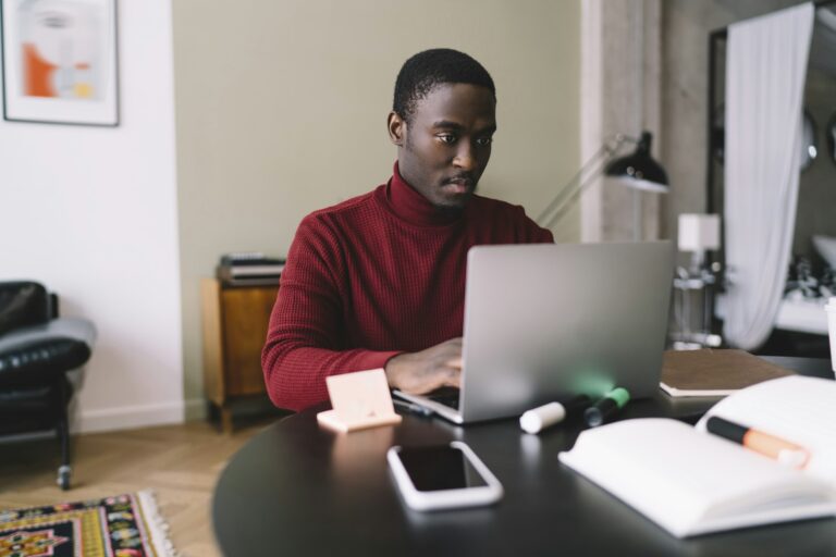 Focused African American freelancer working on laptop